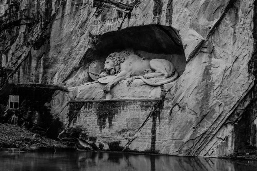 The Lion of Lucerne monument carved into rock, in black and white